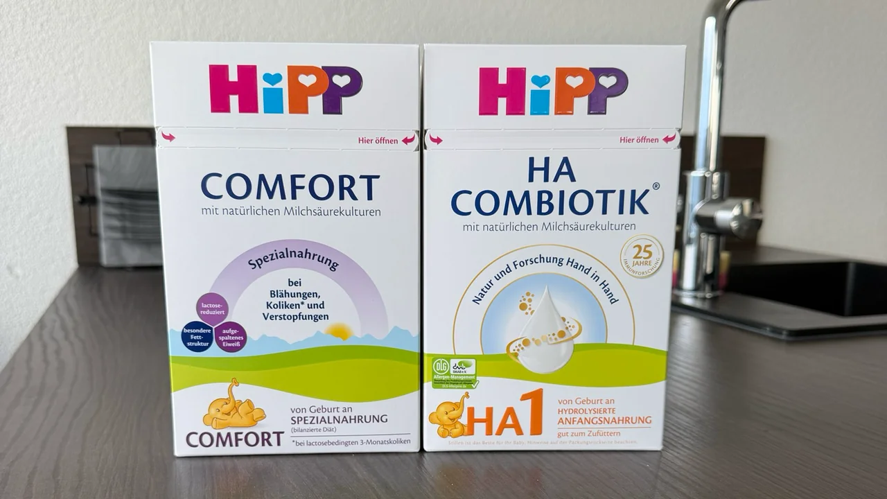 The German HiPP Comfort and HA 1 Combiotik boxes side by side on a kitchen counter, fronts to the camera.